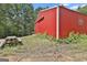 A vibrant red barn with a functional design accompanied by a picnic table for outdoor use at 6220 Petersburg Rd, Fairburn, GA 30213