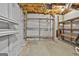 Unfinished basement with exposed ceiling and duct work and wooden shelving at 6220 Petersburg Rd, Fairburn, GA 30213