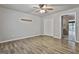 Bright bedroom with wood floors, fan, closet, and a view to attached bathroom at 6220 Petersburg Rd, Fairburn, GA 30213