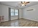 Comfortable bedroom with wood floors, a ceiling fan, and natural light from the window at 6220 Petersburg Rd, Fairburn, GA 30213