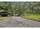 Long, paved driveway leading to the property with a covered parking area on the left at 6220 Petersburg Rd, Fairburn, GA 30213