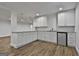 Basement kitchenette featuring white cabinets, granite countertop, mini-fridge and wood-look flooring at 6220 Petersburg Rd, Fairburn, GA 30213
