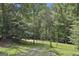 View of land with gate surrounded by mature trees and lush greenery at 6220 Petersburg Rd, Fairburn, GA 30213