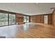 Spacious living room with wood paneling, a fireplace, and large windows at 6220 Petersburg Rd, Fairburn, GA 30213