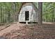 A quaint outbuilding nestled among trees with an open doorway for easy access and ventilation at 6220 Petersburg Rd, Fairburn, GA 30213
