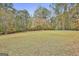 Expansive backyard features green lawn and mature trees providing privacy and natural beauty at 375 Darren Dr, Fayetteville, GA 30215