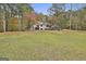 Sprawling backyard with mature trees and lush lawn surrounding the home's exterior and outdoor spaces at 375 Darren Dr, Fayetteville, GA 30215