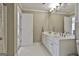 Bathroom with double sink vanity, white tile floor, and an open doorway at 375 Darren Dr, Fayetteville, GA 30215