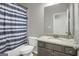 Cozy bathroom features a vanity with granite countertop, toilet, and a shower/tub with blue and white patterned curtain at 2004 Brittlebank Ln, Lawrenceville, GA 30043