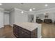 Spacious kitchen island with dark wood cabinets, granite counters and hardwood floors, open to the living room and staircase at 2004 Brittlebank Ln, Lawrenceville, GA 30043