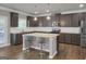 Modern kitchen featuring a granite island with seating, dark cabinetry, stainless steel appliances, and hardwood flooring at 2004 Brittlebank Ln, Lawrenceville, GA 30043