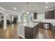 Open-concept kitchen with a granite island, dark cabinets, stainless appliances, and hardwood floors flowing into the living area at 2004 Brittlebank Ln, Lawrenceville, GA 30043