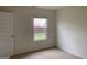 Cozy bedroom featuring carpeted floors, natural light from a window, and white trim at 1636 Jersey Dr, Stockbridge, GA 30281