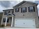 Beautiful two-story home featuring a brick exterior, an attached garage, and a covered entryway at 1636 Jersey Dr, Stockbridge, GA 30281