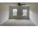 Spacious main bedroom featuring carpeted floors, a ceiling fan, and natural light from large windows at 1636 Jersey Dr, Stockbridge, GA 30281