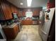 Functional kitchen with wood cabinets, tile floors, and modern stainless steel appliances at 2119 Amherst Se Trl, Conyers, GA 30094