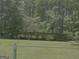 Large fenced backyard featuring a covered shelter and lush lawn, ideal for outdoor activities at 260 Willis Rd, Sharpsburg, GA 30277