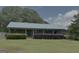Charming brick ranch-style home with a metal roof, front porch, and mature landscaping at 260 Willis Rd, Sharpsburg, GA 30277