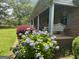 Inviting front porch of brick home with lovely landscaping and a cozy swing at 260 Willis Rd, Sharpsburg, GA 30277