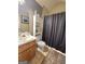 Traditional bathroom with a light wood vanity, toilet, and shower with a dark shower curtain at 165 Cedar Ridge Rd, Locust Grove, GA 30248