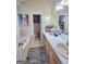 Well-lit bathroom featuring double sinks, white countertops, wooden cabinets, and a separate tub at 165 Cedar Ridge Rd, Locust Grove, GA 30248