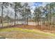 Picturesque backyard view of a serene lake surrounded by lush trees and natural landscaping at 4090 Sandy Lake Dr, Lithonia, GA 30038