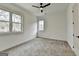 A bright bedroom with plush carpet features multiple windows and a ceiling fan at 4090 Sandy Lake Dr, Lithonia, GA 30038
