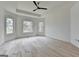 Bedroom with hardwood flooring, a tray ceiling with ceiling fan, and large windows at 4090 Sandy Lake Dr, Lithonia, GA 30038