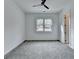 A serene bedroom features plush gray carpet, a modern ceiling fan, and ample natural light at 4090 Sandy Lake Dr, Lithonia, GA 30038