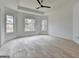 Bedroom with hardwood flooring, a tray ceiling with ceiling fan, and large windows at 4090 Sandy Lake Dr, Lithonia, GA 30038
