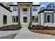 Sophisticated two-story home with a white brick exterior, black window frames, and a covered entry at 4090 Sandy Lake Dr, Lithonia, GA 30038