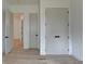 Hallway with hardwood floors, white trim, and multiple doors with matte black hardware at 4090 Sandy Lake Dr, Lithonia, GA 30038