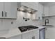 Close-up of modern kitchen with stainless steel appliances, marble backsplash, and sleek white cabinets at 4090 Sandy Lake Dr, Lithonia, GA 30038