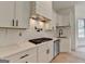 Close-up of modern kitchen with stainless steel appliances, marble backsplash, and sleek white cabinets at 4090 Sandy Lake Dr, Lithonia, GA 30038