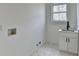 Laundry room with marble floors, modern white cabinets and sink with contrasting matte black faucet at 4090 Sandy Lake Dr, Lithonia, GA 30038