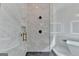 Detailed view of the shower with marble tiles, black fixtures, and glass enclosure at 4090 Sandy Lake Dr, Lithonia, GA 30038