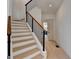 Modern staircase featuring hardwood treads, white risers, and a black metal railing at 4090 Sandy Lake Dr, Lithonia, GA 30038