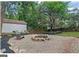 Stone patio with a built-in firepit, landscaping, and mature trees provide a relaxing backyard oasis at 1042 Faith Se Ave, Atlanta, GA 30316