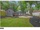Large backyard with mature trees, a storage shed, landscaping, and a firepit area at 1042 Faith Se Ave, Atlanta, GA 30316