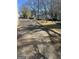 View of a long driveway leading to a property with various structures and landscaping at 702 Emily Nw Pl # 0, Atlanta, GA 30318