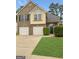 Two-story home featuring a brick facade, two-car garage, and lush landscaping at 120 Hawken Trl, Mcdonough, GA 30253