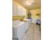Bright laundry room features white cabinets, and a washer and dryer next to an ironing board at 120 Hawken Trl, Mcdonough, GA 30253