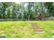 Expansive backyard featuring a playset, trampoline, basketball hoop, and tiered landscaping at 1849 Wanda Way, Ellenwood, GA 30294