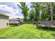 The backyard features a generous grassy area with a fence, bordered by tall trees at 1849 Wanda Way, Ellenwood, GA 30294