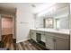 Well-lit bathroom boasts a double vanity with sleek cabinets and wood flooring, enhancing the room's appeal at 1849 Wanda Way, Ellenwood, GA 30294