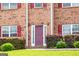 Detailed view of a brick home's entrance with a dark door, sidelights, and trimmed landscaping at 1849 Wanda Way, Ellenwood, GA 30294