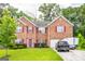 Beautiful two-story brick home featuring red shutters, a well-manicured lawn, and mature trees at 1849 Wanda Way, Ellenwood, GA 30294