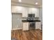 Kitchen area with white cabinets, stainless steel appliances, and hardwood flooring at 1433 Cotton Sw Trl, Conyers, GA 30094