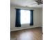 Bright bedroom featuring a ceiling fan, wood floors, and a window with dark curtains at 14104 Fairington Ridge Cir, Lithonia, GA 30038