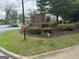 Manicured landscaping surrounds the community sign at Harrington Ridge in front of wooded area and other apartments at 14104 Fairington Ridge Cir, Lithonia, GA 30038